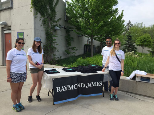 4 people with Raymond James banner